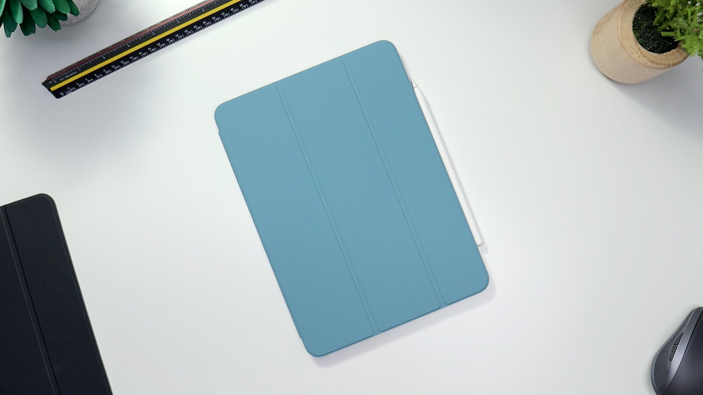 Tablet con stilo e cancelleria disposti su una scrivania.